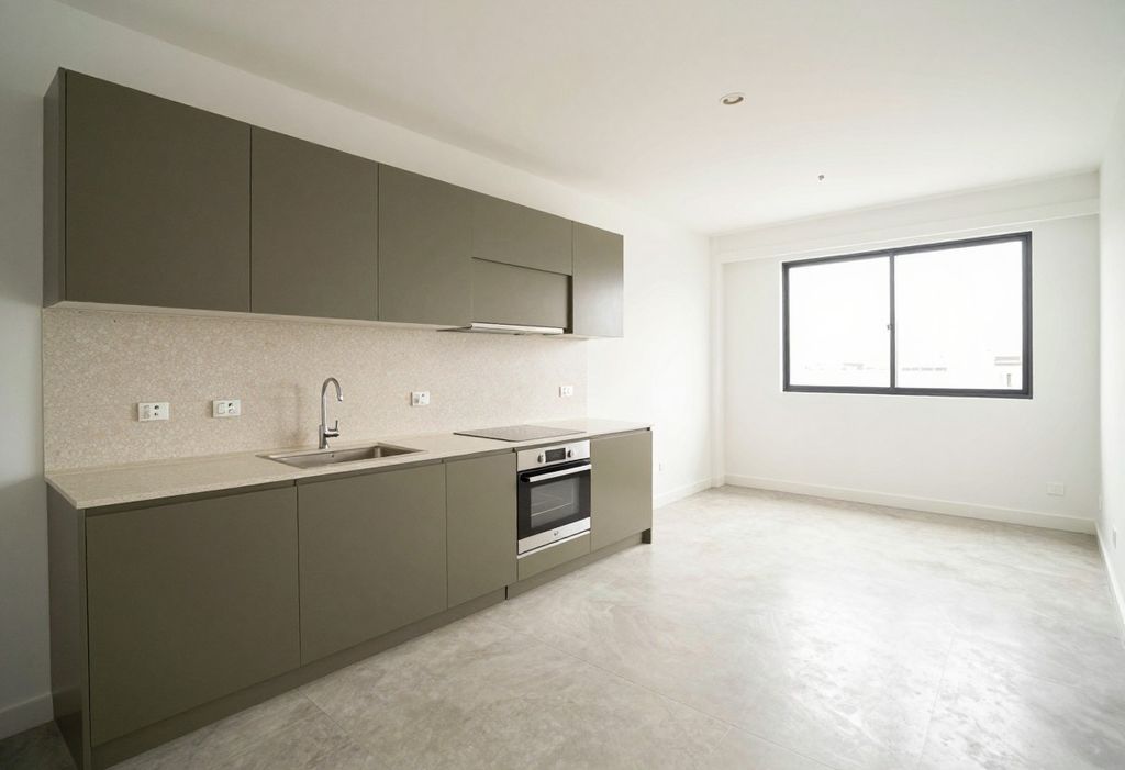 Cocina abierta con muebles verde oliva, encimera de terrazo y horno empotrado