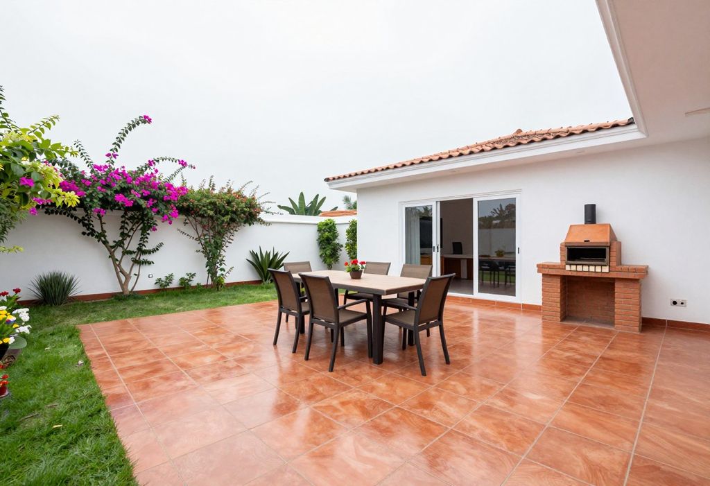 Terraza de baldosas de arcilla con mesa para ocho, parrilla de ladrillo y buganvilla en el muro